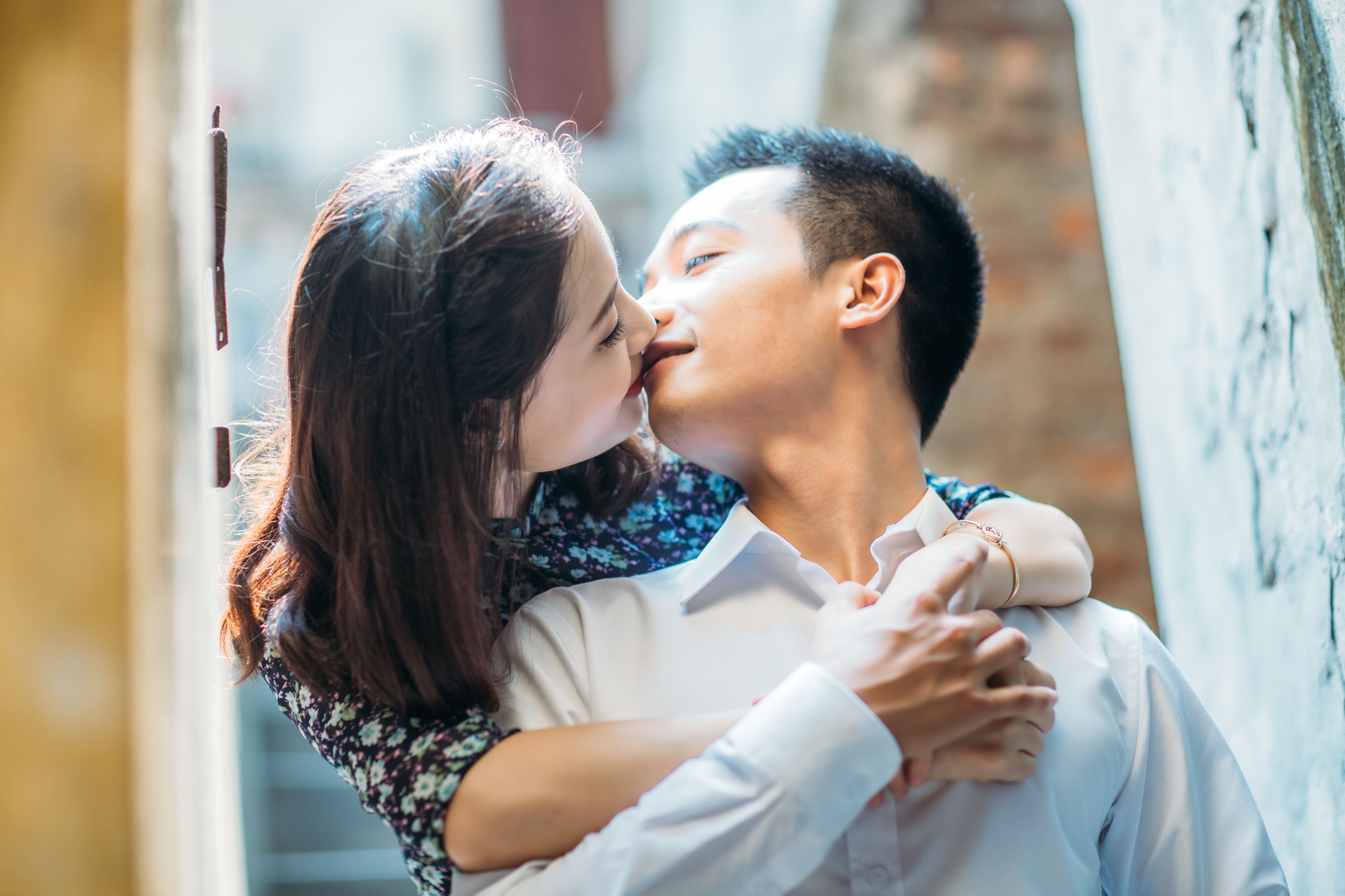 Young couple sharing a tender moment in an urban alleyway, expressing love and romance.