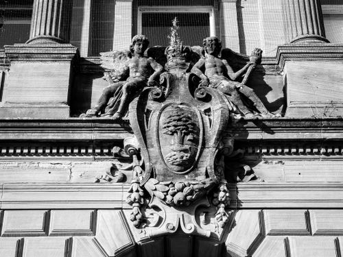 Free Black and white photo of detailed architectural relief with two sculpted figures, showcasing classic design. Stock Photo