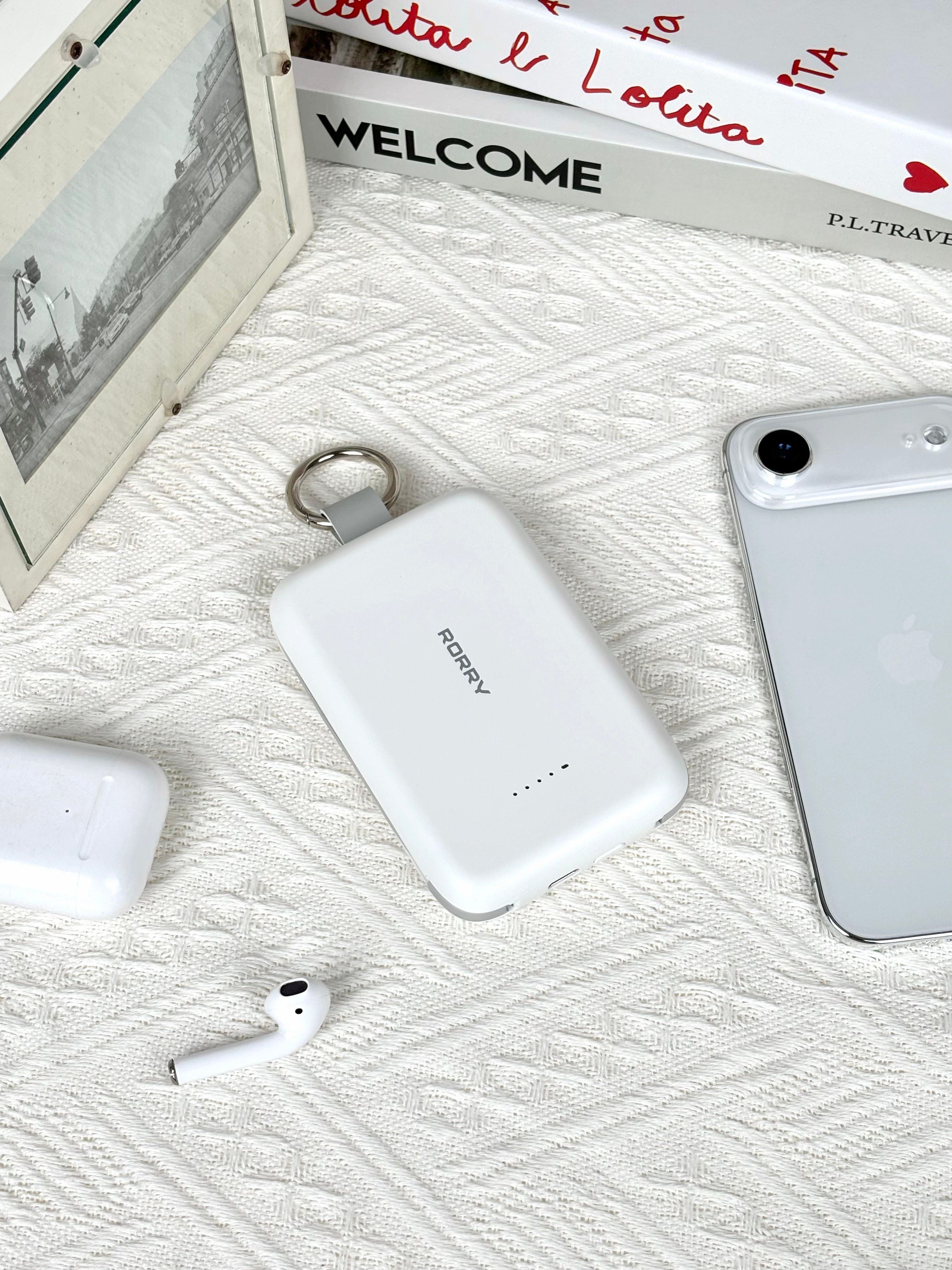Flat lay of tech gadgets including a smartphone, audio accessories, and a power bank on a quilted surface.