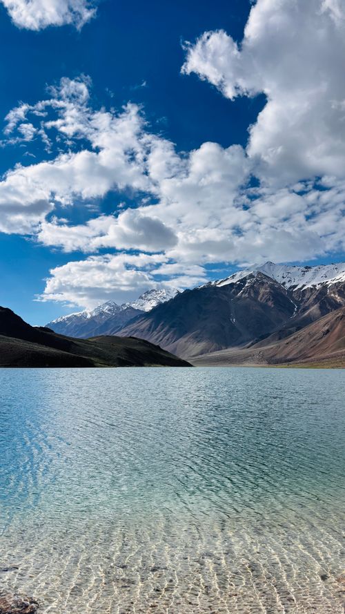 Free Crystal-clear lake with snow-capped mountains under a bright blue sky in Himachal Pradesh, India. Stock Photo