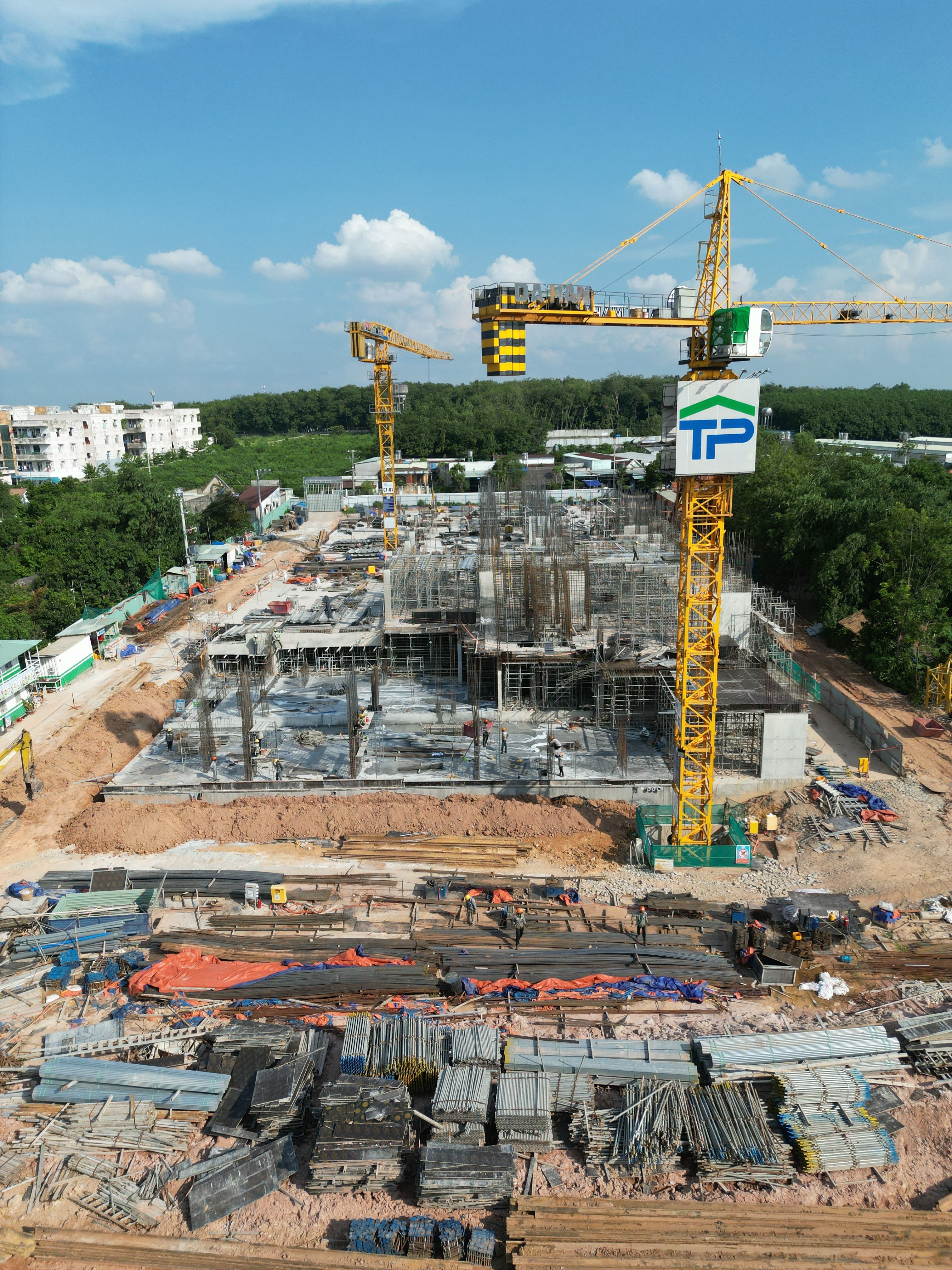Dynamic aerial photo showcasing tower cranes at a busy construction site.