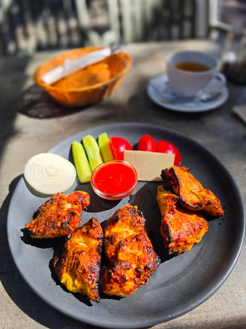 Free Delicious grilled chicken with vegetables on a terrace in Tallinn, ideal for outdoor dining lovers. Stock Photo