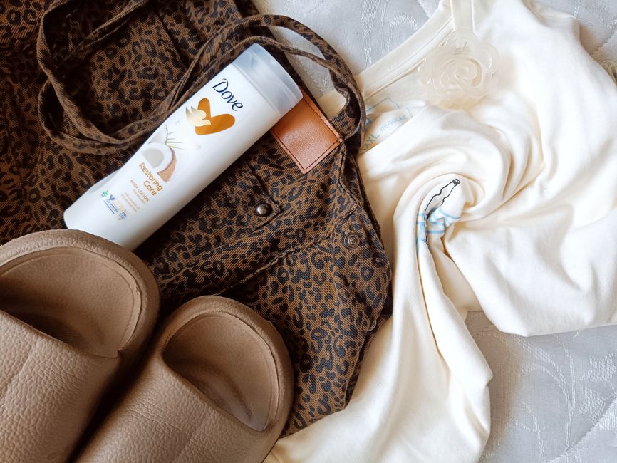Fotomural Una imagen plana que muestra artículos de moda y cuidado personal, incluyendo un bolso con estampado de leopardo, crema y zapatillas.