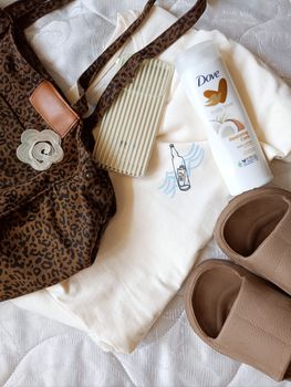 Flat lay image featuring accessories and Dove body lotion on a surface.