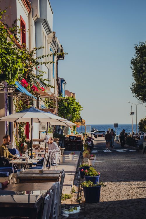 Free Quaint seaside café with colorful buildings and outdoor seating on a sunny summer day. Stock Photo