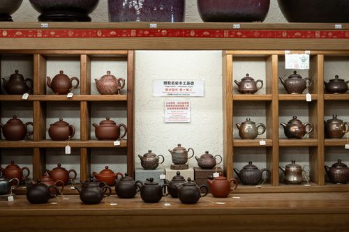 Free A collection of traditional teapots on wooden shelves in New Taipei City, Taiwan. Stock Photo
