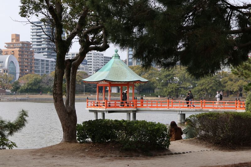 Red pavilion on a bridge over the pond in Ohori Park, Fukuoka