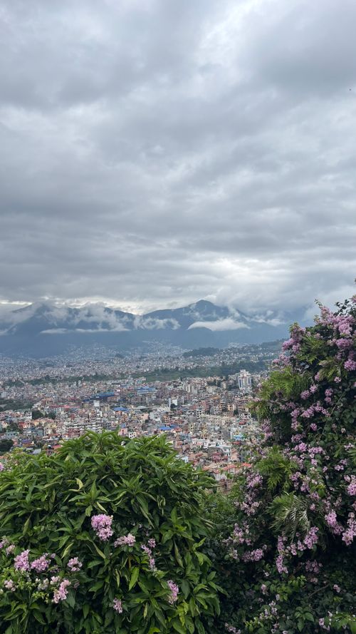 Free Breathtaking view of Kathmandu cityscape with lush greenery and distant mountains under a cloudy sky. Stock Photo