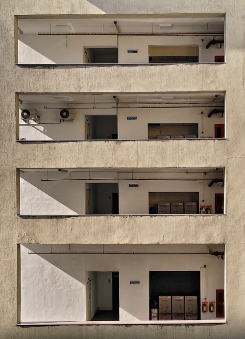 Free Modern building facade showcasing geometric balconies and shadows on a sunny day. Stock Photo