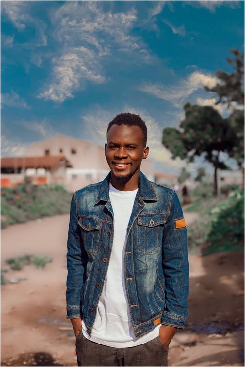 Free Portrait of a smiling man in a denim jacket against a blue sky background. Stock Photo