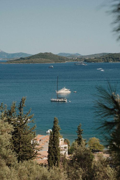 Free Discover the serene beauty of Lefkada's coastline with vibrant blue waters and lush greenery. Stock Photo