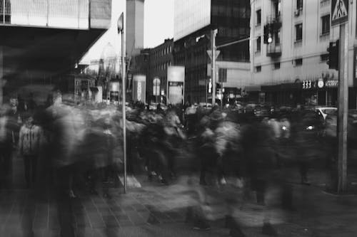 Grayscale Photo Of Blurry People Walking