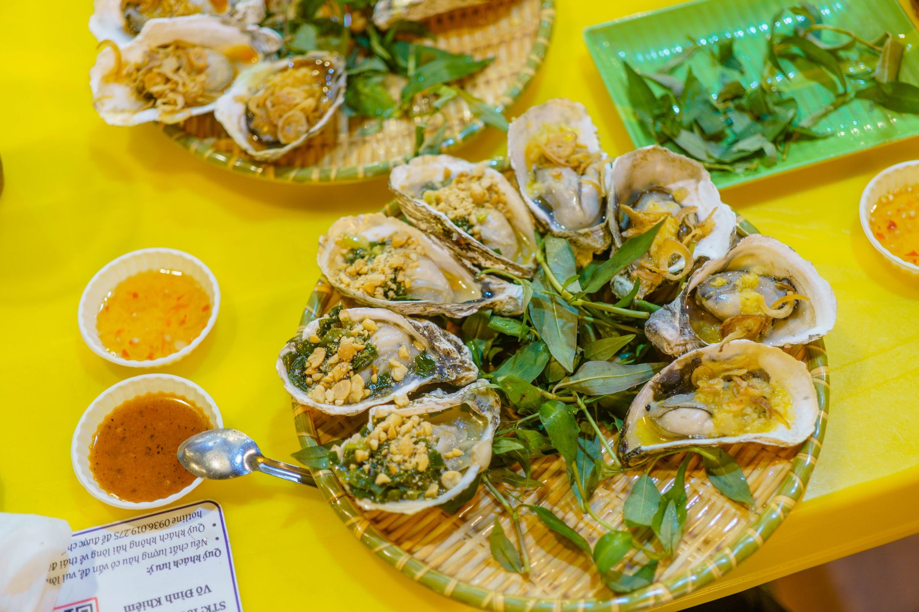 Delicious oysters served on a platter with dipping sauces and garnished with fresh herbs.
