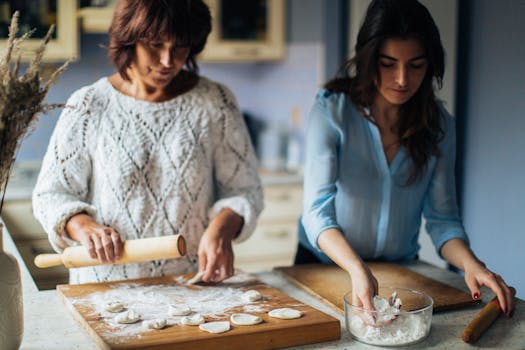 Mother and daughter in kitchen preparing traditional dumplings together. A warm and homely scene.