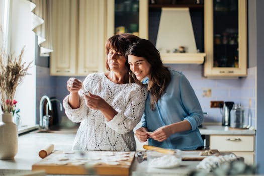 Mother and daughter bonding while making dumplings in a cozy kitchen setting.