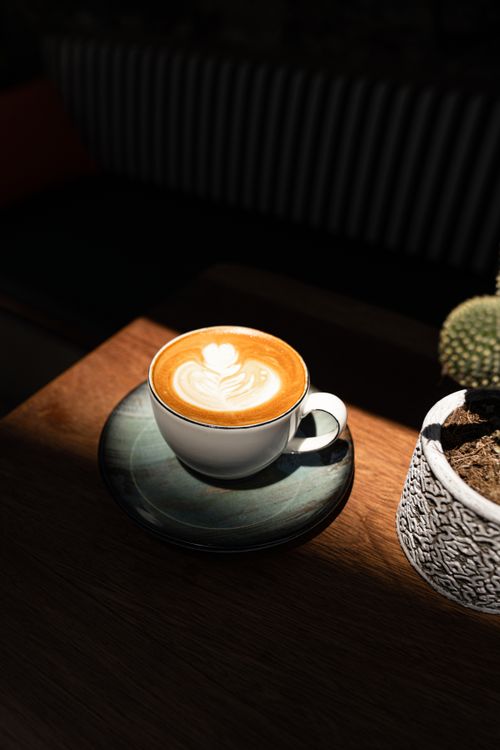 Free A beautifully crafted latte with latte art, captured in warm natural lighting. Stock Photo