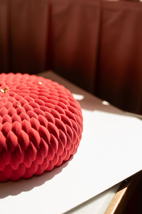 Free Artistic round red velvet cake with unique textures in warm sunlight, creating a vibrant and inviting atmosphere. Stock Photo
