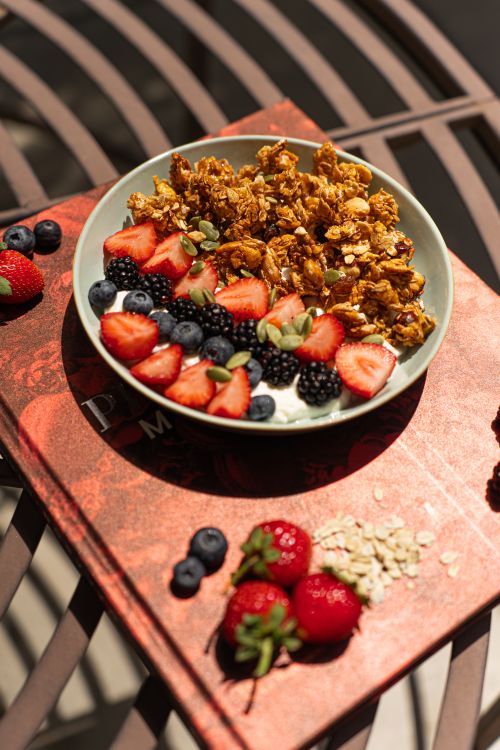 Free A vibrant breakfast bowl featuring granola, strawberries, blueberries, and blackberries under natural light. Stock Photo