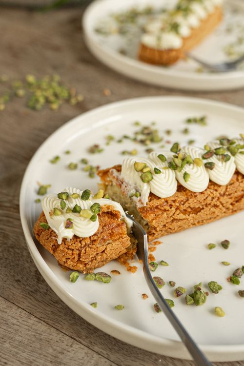 Free Delicious pistachio pastry with cream on a white plate, perfect for gourmet dining. Stock Photo