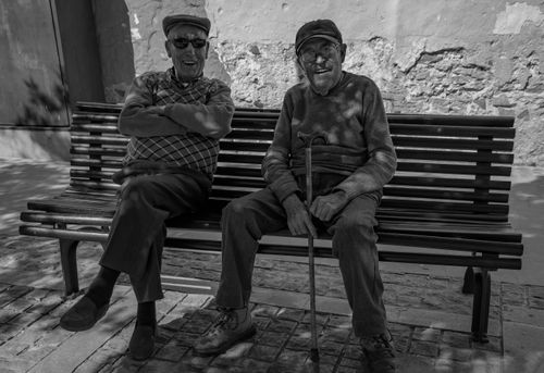 Free Two senior men enjoying a sunny day on a bench in Bocairente, Spain. Stock Photo