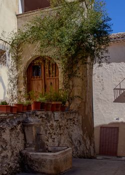 Rustic stone corner with potted plants and archway in Bocairente's historic area.