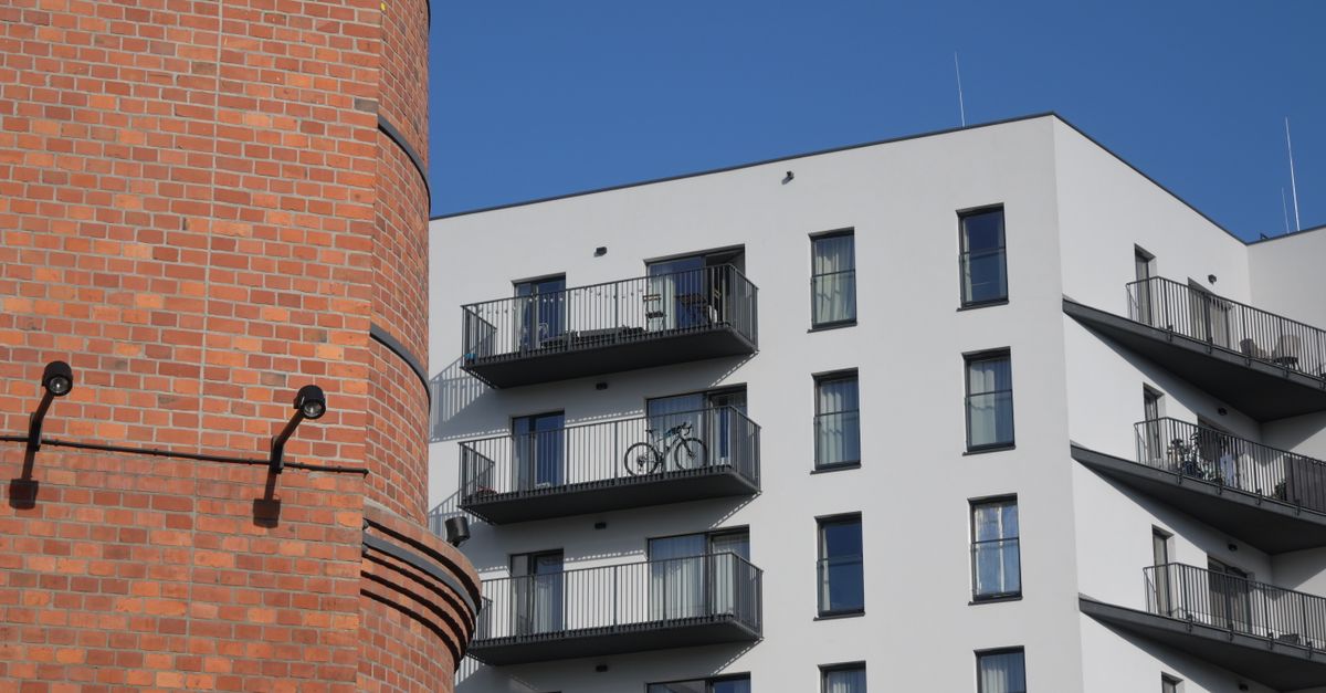 A modern apartment building next to a traditional brick structure in Warsaw, Poland.