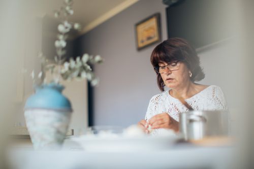 Free An adult woman is focused on preparing traditional dumplings in a cozy kitchen setting. Stock Photo