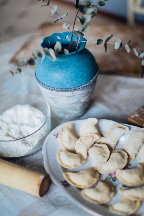 Free A cozy still life of homemade dumplings with flour and a decorative vase. Stock Photo