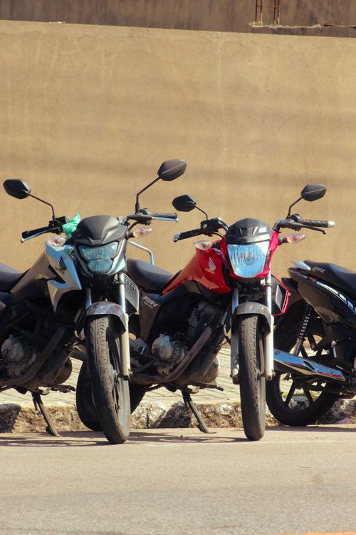 Free Close-up of four parked motorcycles in a sunny urban setting. Stock Photo