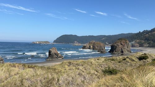 Free Stunning view of rock formations and sand dunes along the Oregon coast on a sunny day. Stock Photo