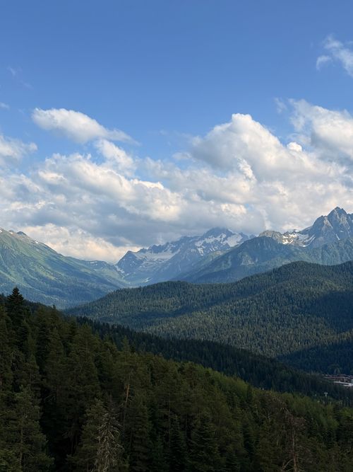 Free Breathtaking view of the Caucasus Mountains with lush forests and clear skies. Stock Photo