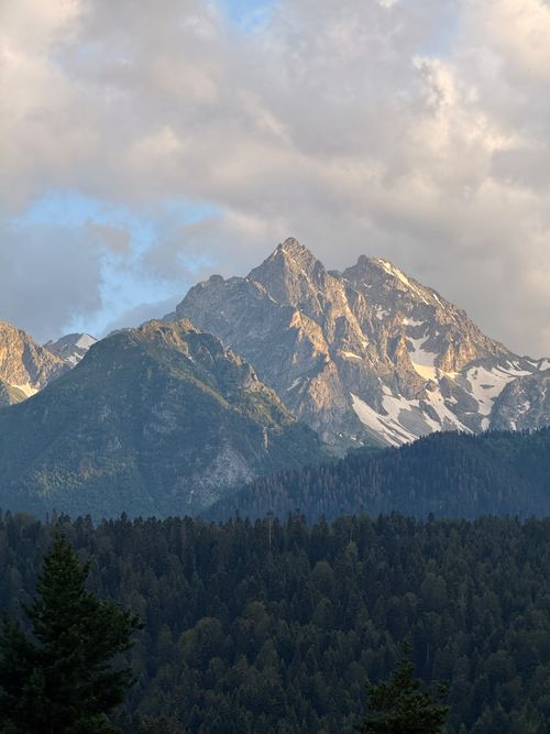 Free Captivating view of the snow-capped Caucasus Mountains under cloudy sky during sunset. Stock Photo