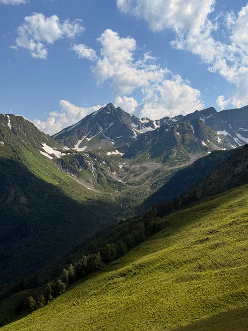 Free Breathtaking view of the lush green slopes and snow-capped peaks of the majestic Caucasus Mountains. Stock Photo