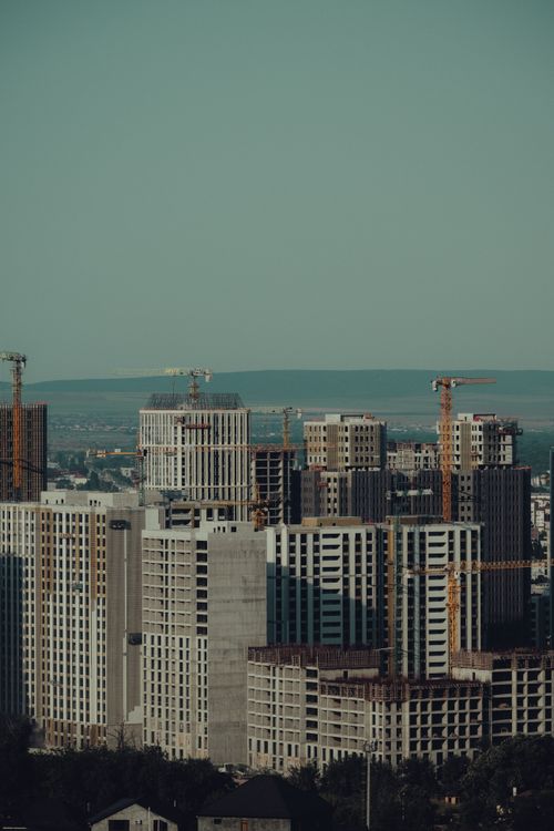 Free Urban skyline of Grozny, Russia, featuring high-rise buildings and cranes under a clear sky. Stock Photo
