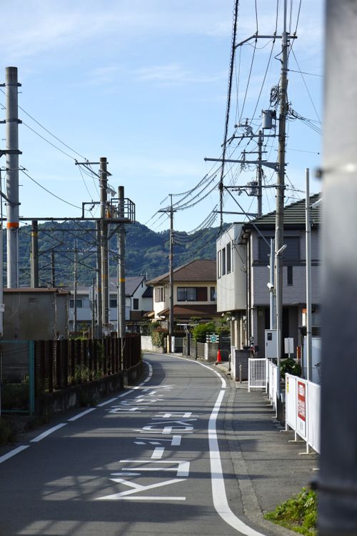 Free A peaceful street scene in Kinokawa, showcasing local life with residential buildings and mountains. Stock Photo