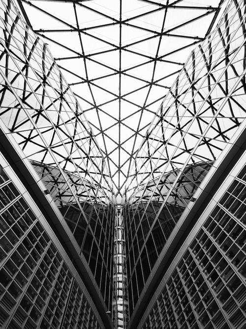 Free A striking black and white image of a modern glass atrium with geometric patterns and reflections. Stock Photo