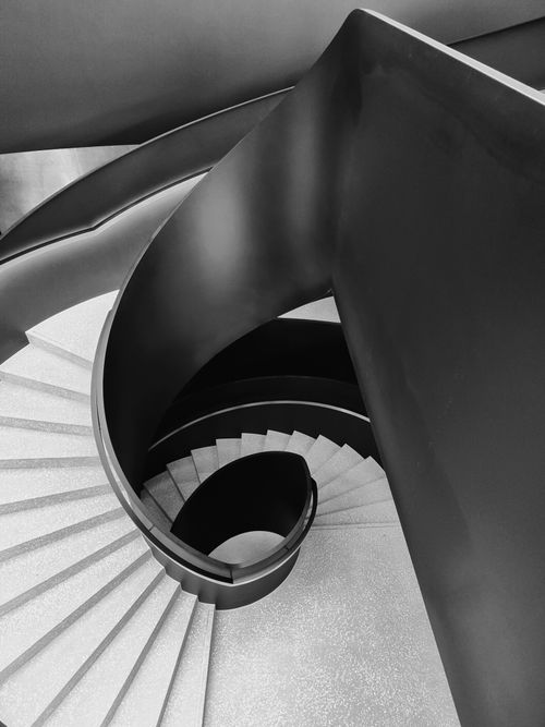 Free Dramatic black and white photo of a modern spiral staircase Stock Photo
