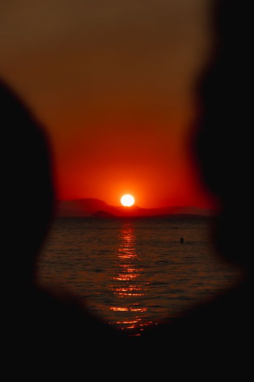 Free Magnificent sunset over Aegean Sea in Greece with vivid orange hues and tranquil water reflections. Stock Photo