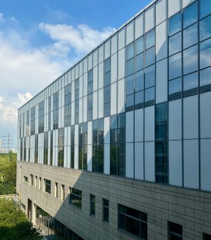 Contemporary office building with glass facade under blue skies in Suzhou, Jiangsu.