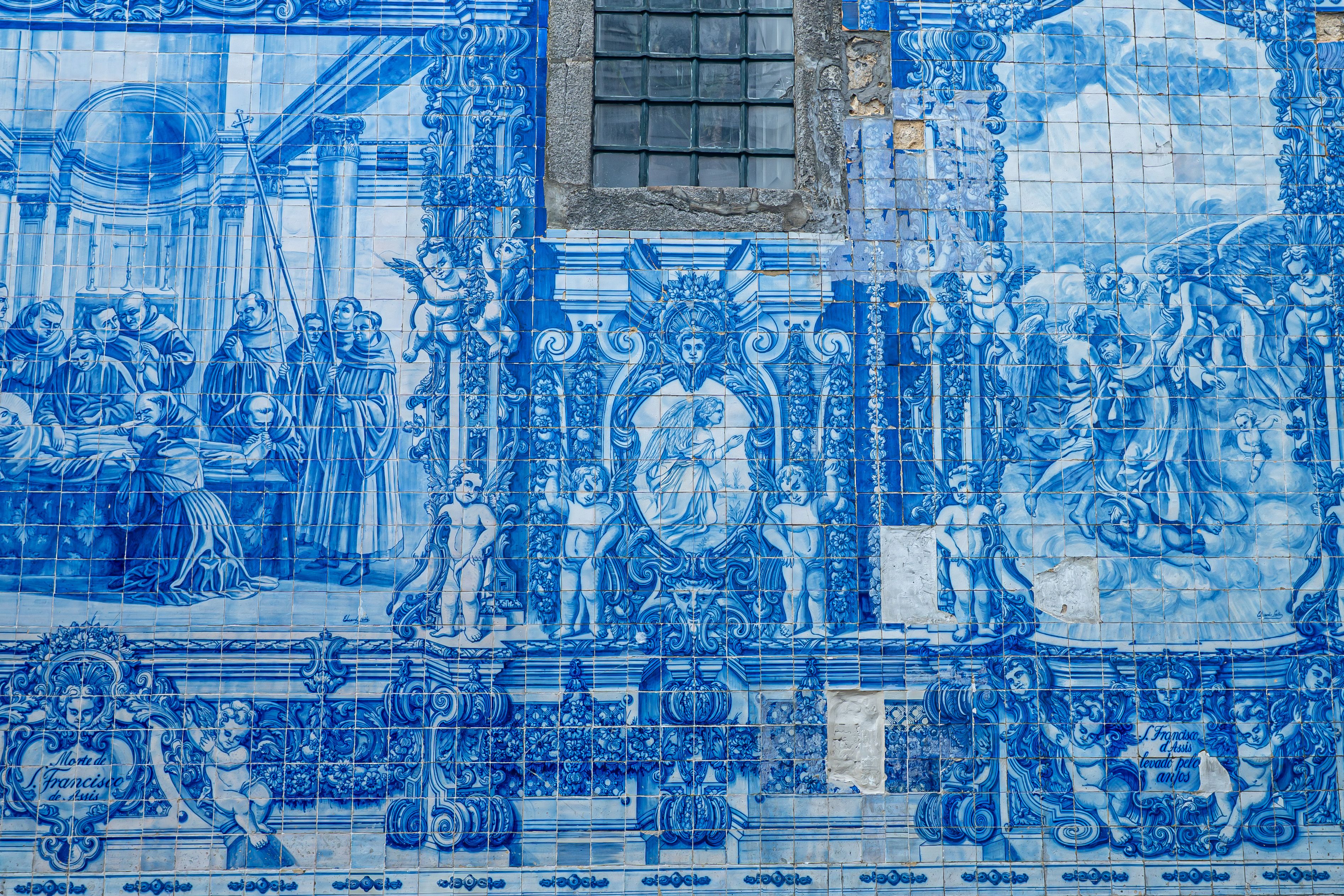 Fotomural Cautivador mural de azulejos azules y blancos que representa escenas históricas y religiosas de Oporto.