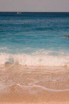 Stunning beach view at Lefkada with turquoise waters and swimmers enjoying summer vibes.
