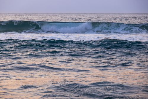 Free Serene ocean waves captured at sunset, creating a calming and picturesque seascape. Stock Photo