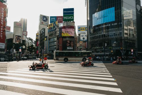 Free Shibuya crossing bustling with go-karts and city life in Tokyo, Japan. Stock Photo