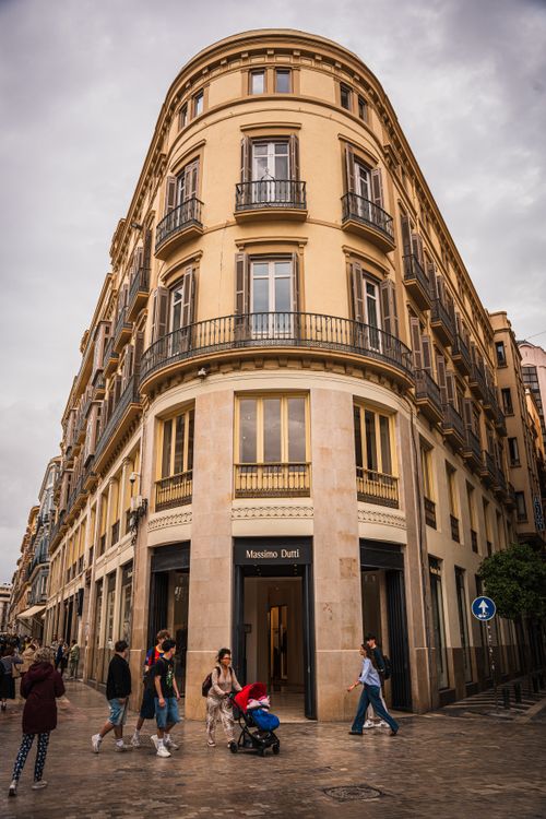 Free Urban scene with people walking by an elegant corner building in a European city, Massimo Dutti store. Stock Photo
