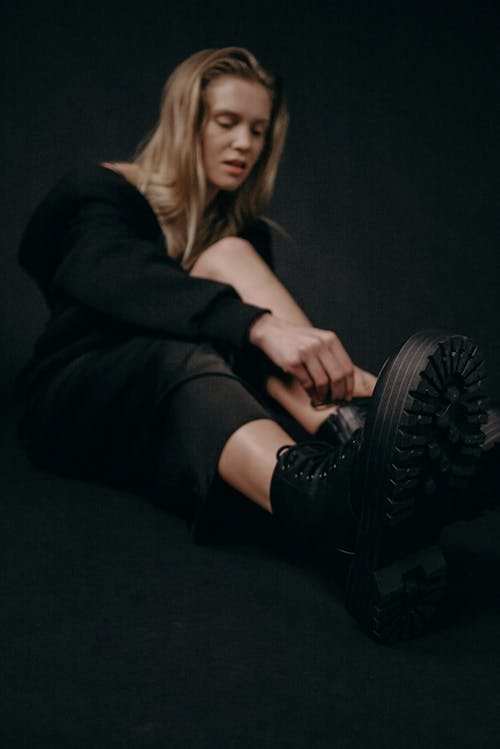 Woman in Black Long Sleeved Top and Black Skirt Sitting on Floor