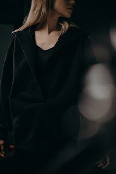 一位身着深色极简主义服装的金发女子，散发着神秘与优雅