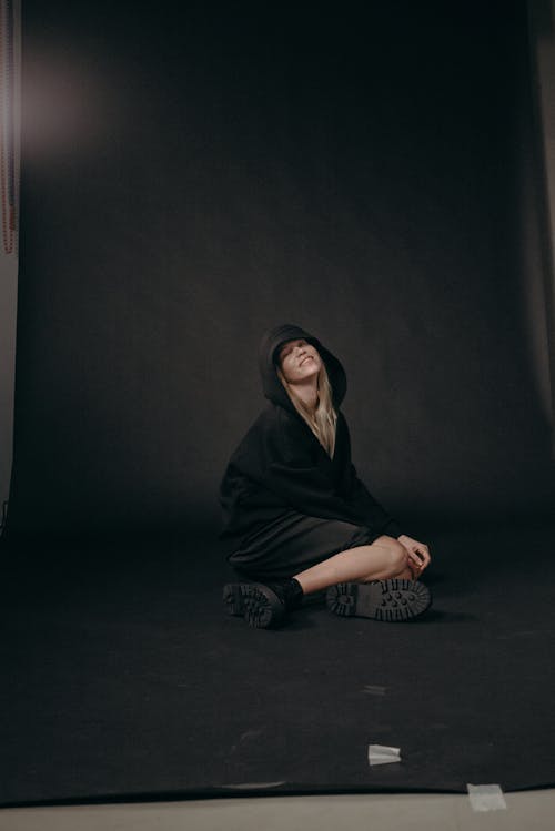 Woman in Black Hoodie Sitting on Floor