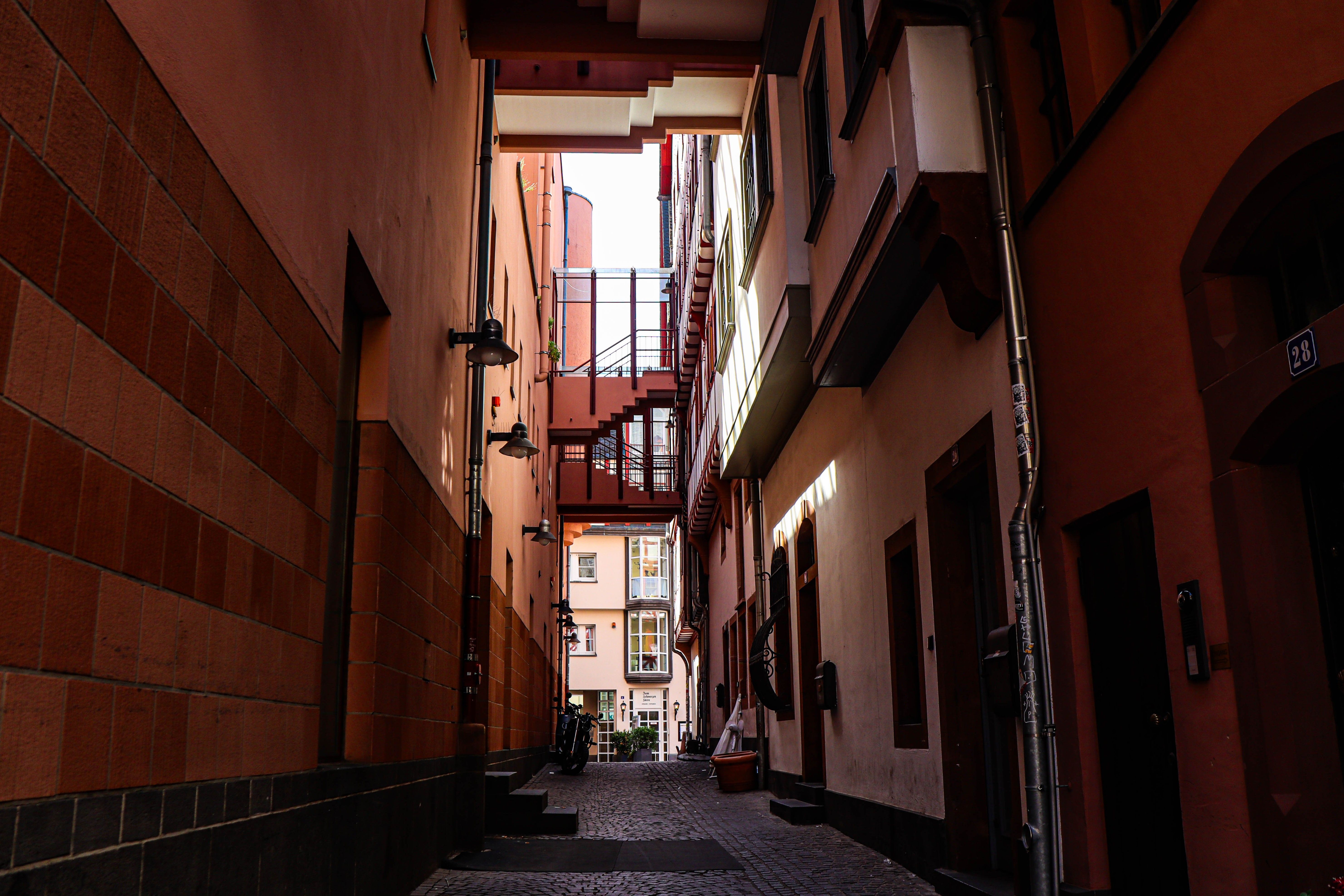 Callejón estrecho colonial con sombras dramáticas