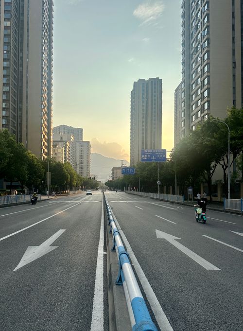 Free Modern skyscrapers lining an empty road in Chongqing, China, captured at sunset, creating a serene cityscape. Stock Photo
