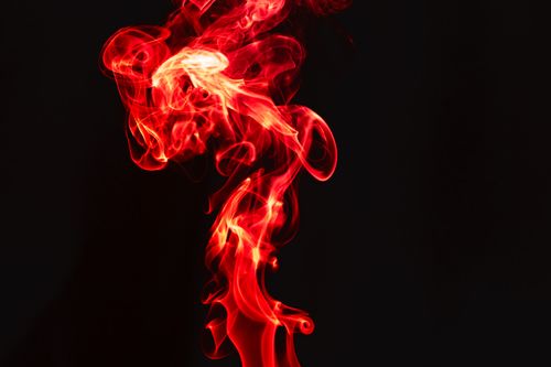 Free Abstract swirling red smoke set against a contrasting black background. Stock Photo
